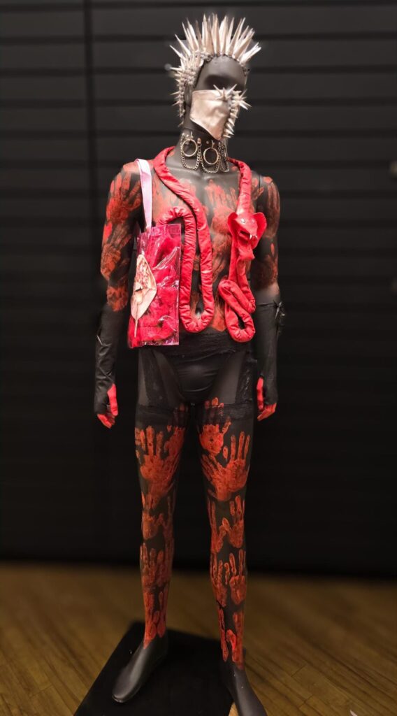 A Mannequin made by Monette Walker showing Temptation and regreat and also being caught red handed. The Mannequin is covered in red and waist and below red paint handprints cover the pants.