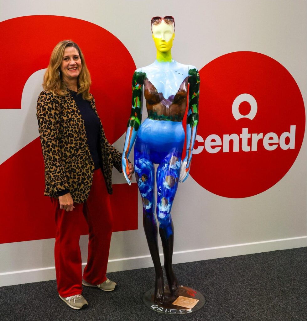 An image showing Rona Kane standing next to the Mannequin designed to show Grief. 