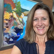 An image showing Rona Kant standing in front of a colourful mural 